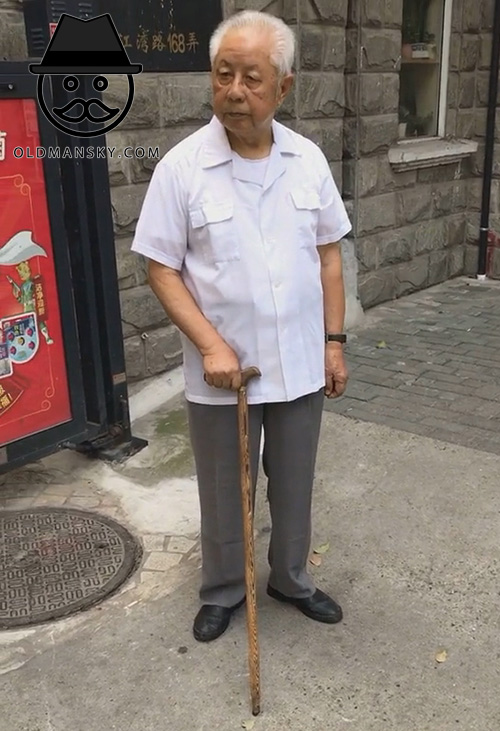 White hair old man took a cane walked in the street