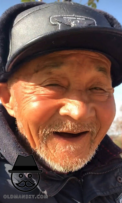 White beard old man wore a black cap enjoyed sunshine