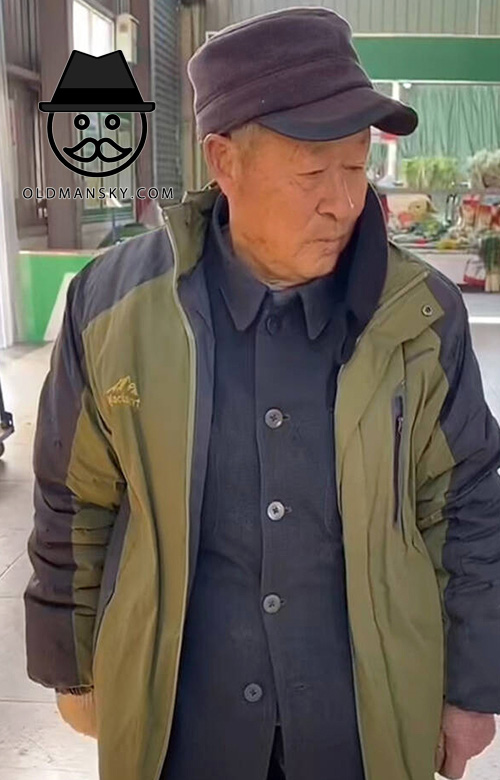 Old man wore a cap and in green coat at home