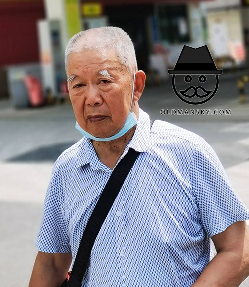 Short white hair old man carried a black satchel in the street
