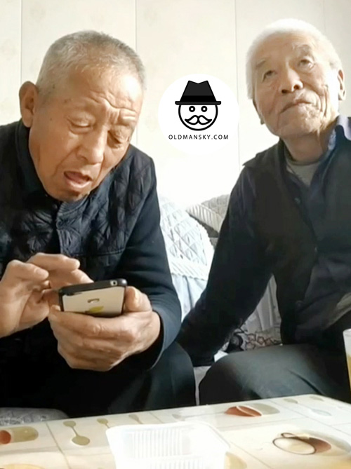 Two old men were drinking tea on the sofa