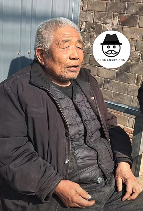 Silver hair old man in gray winter clothes sat on the roadside