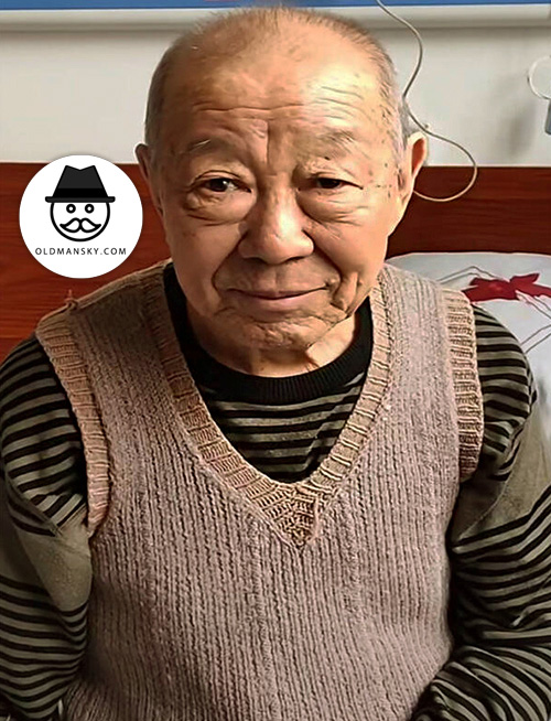 Old man in a knitted sweater sat on the bed