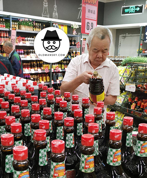 White hair old man bought soy sauce in the supermarket