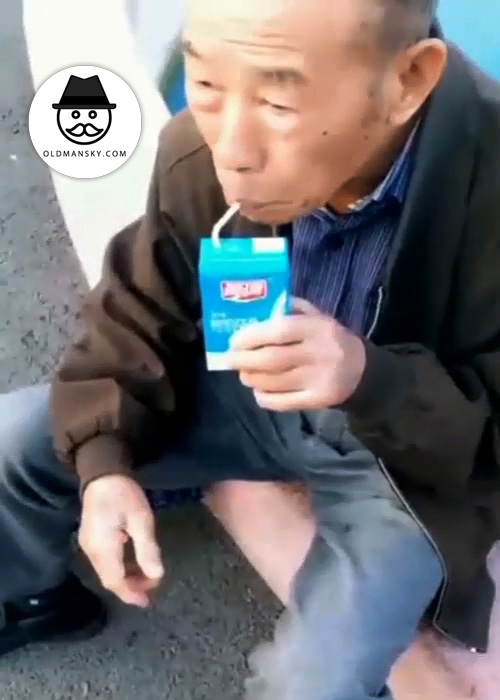 Skinny old man drank milk on the roadside