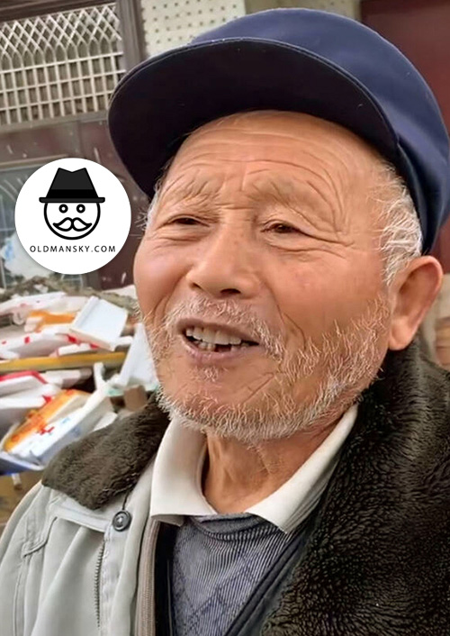 White hair and beard old man wore brown hat on the roadside