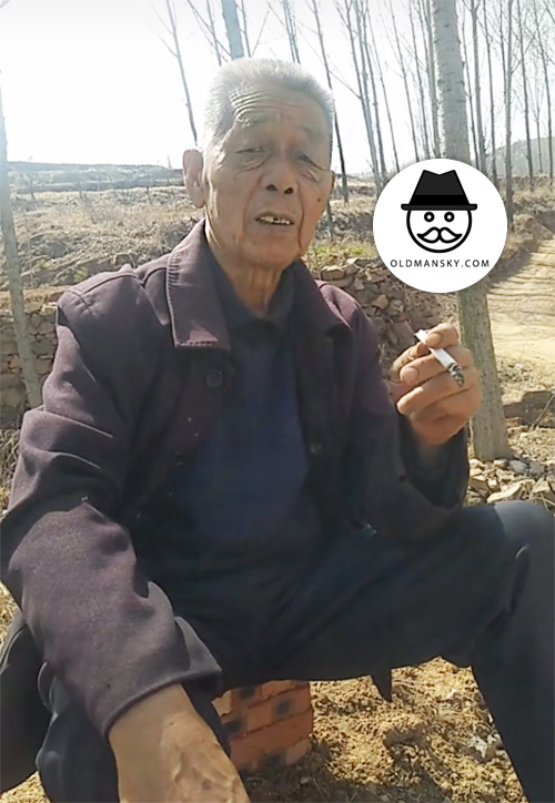 White hair old man smoke in the field