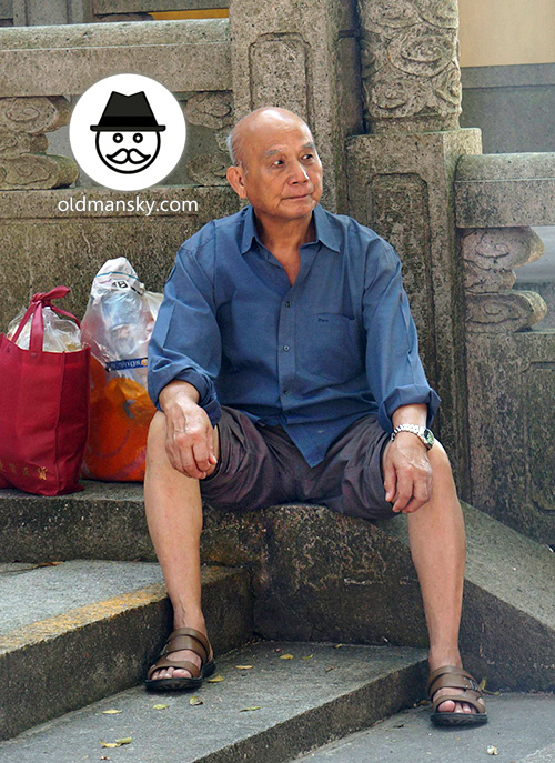 Silver hair old man wore blue shirt sat on the stairs