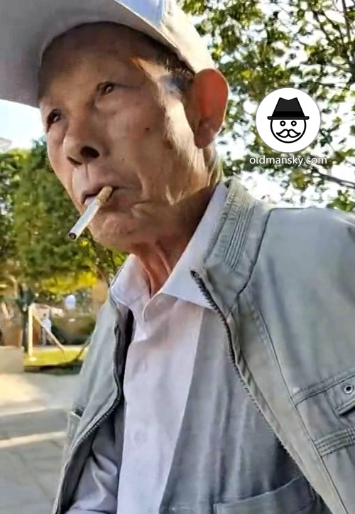 Old man wore a cap smoke and talked in the park