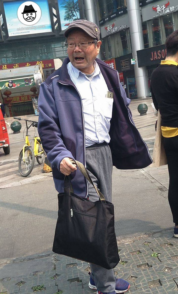 Old man wore a cap and gray trousers at the bus station