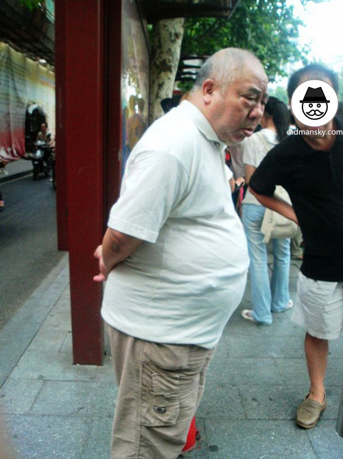 Fat old man wore white polo shirt was waiting bus in the bus station ...