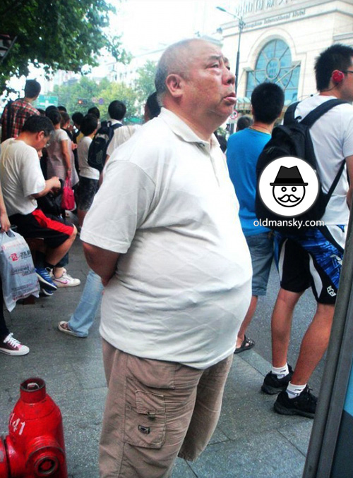 Fat old man wore white polo shirt was waiting bus in the bus station ...