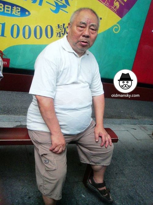 Fat old man wore white polo shirt was waiting bus in the bus station