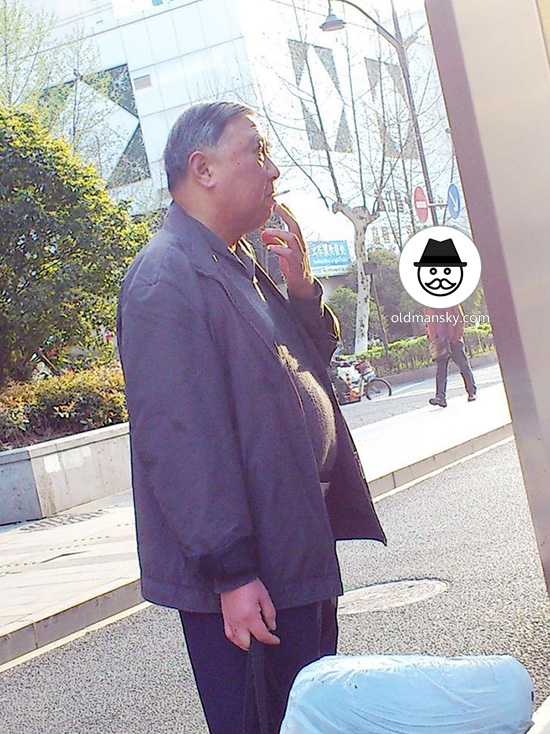 Old daddy wore brown jacket was smoking in the bus station