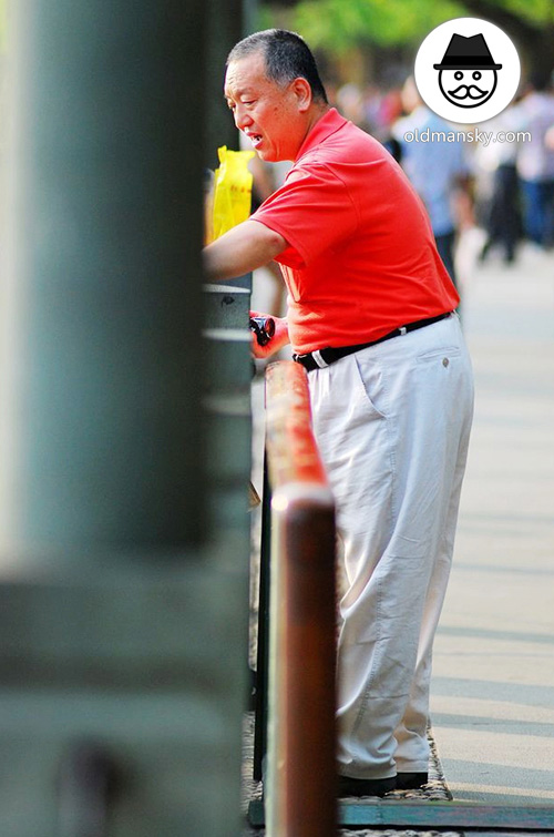 Old daddy wore red polo shirt and white trousers in the park