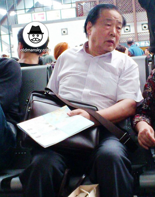 Old daddy wore white shirt in the railway station waiting room