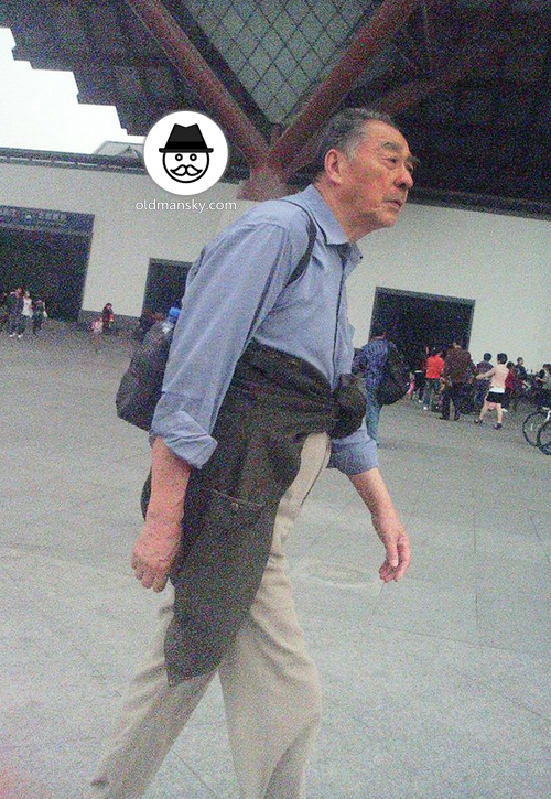 Old man wore blue shirt walked around on the square