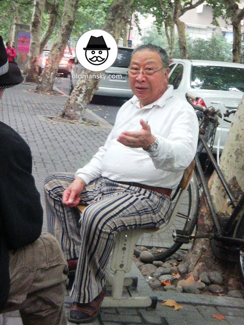 Glasses old man wore a striped trousers talked in the street