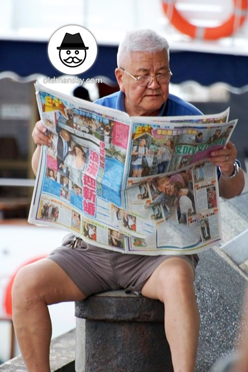 White hair glasses old man wore blue polo shirt and middle pants read newspaper