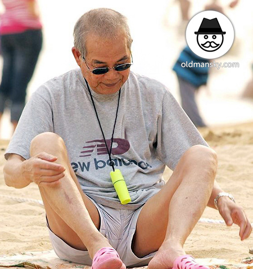 Sunglasses old man wore gray T-shirt sat on the beach