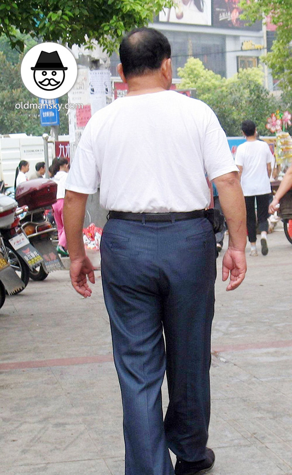 Old daddy wore white undershirt and brown trousers in the street
