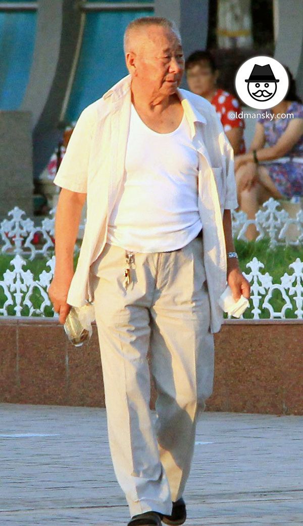 Old man wore white clothes walked around on the square