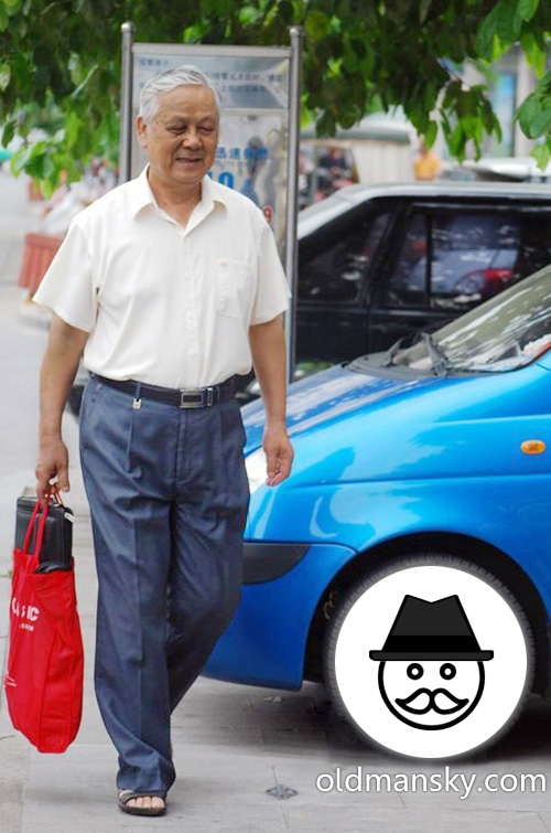 White hair old man wore white shirt and blue trousers in the street