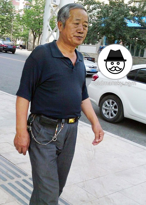 Old daddy wore brown polo shirt and gray trousers walked in the street