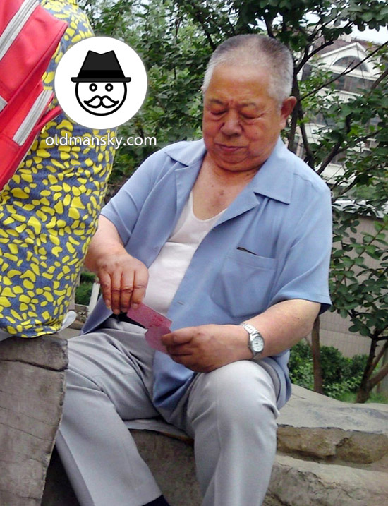 Old daddy wore blue shirt and white trousers was playing poker