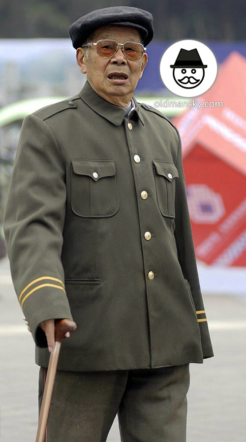 Thin old man walked on the road in military uniform with a crutch_04