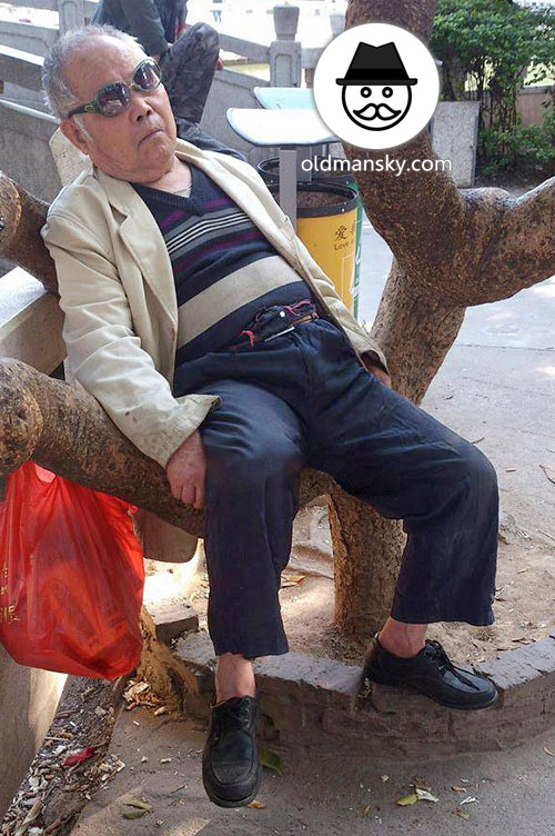 Sunglasses old man sat resting on the tree trunk