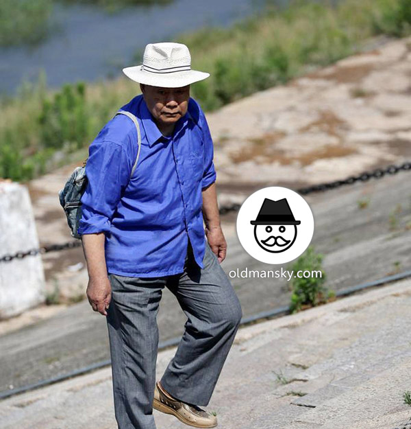 Tourist old daddy wore blue shirt was washing by the river