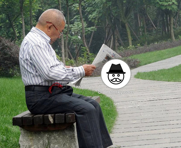 Glasses old daddy wore strip shirt was reading newspaper on the bench_02