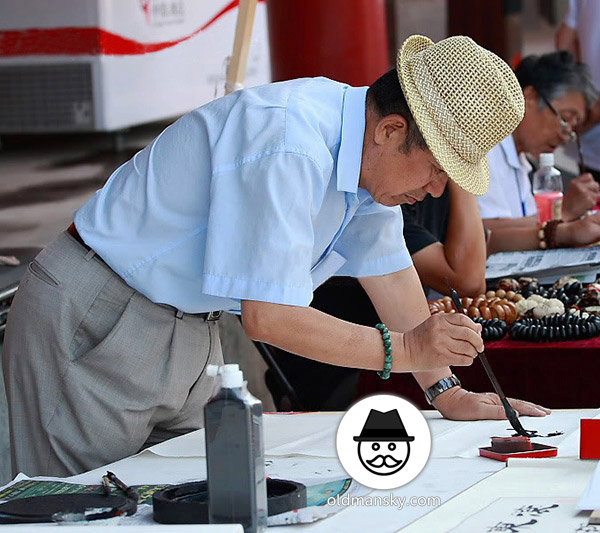 Old daddy wore blue shirt and a hat was writing in the street_05