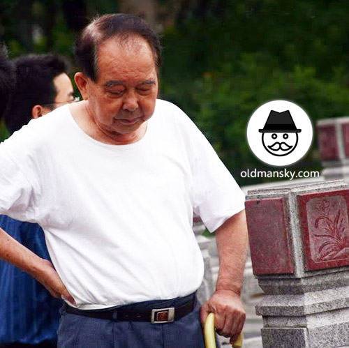 Old daddy wore white shirt and blue trousers in the park