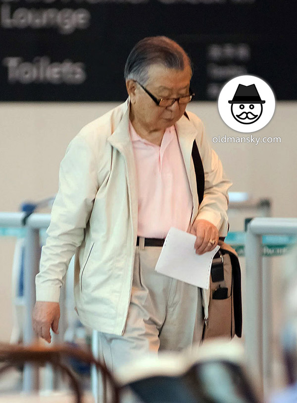 Glasses old man wore white clothes went to buy plane ticket in the airport