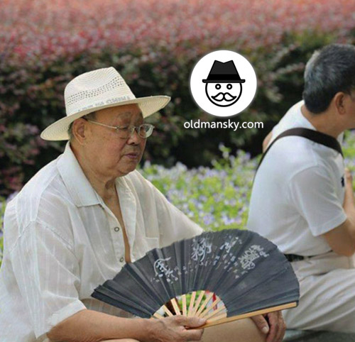 Glasses old man wore a white hat and took a fan rest in the park_04