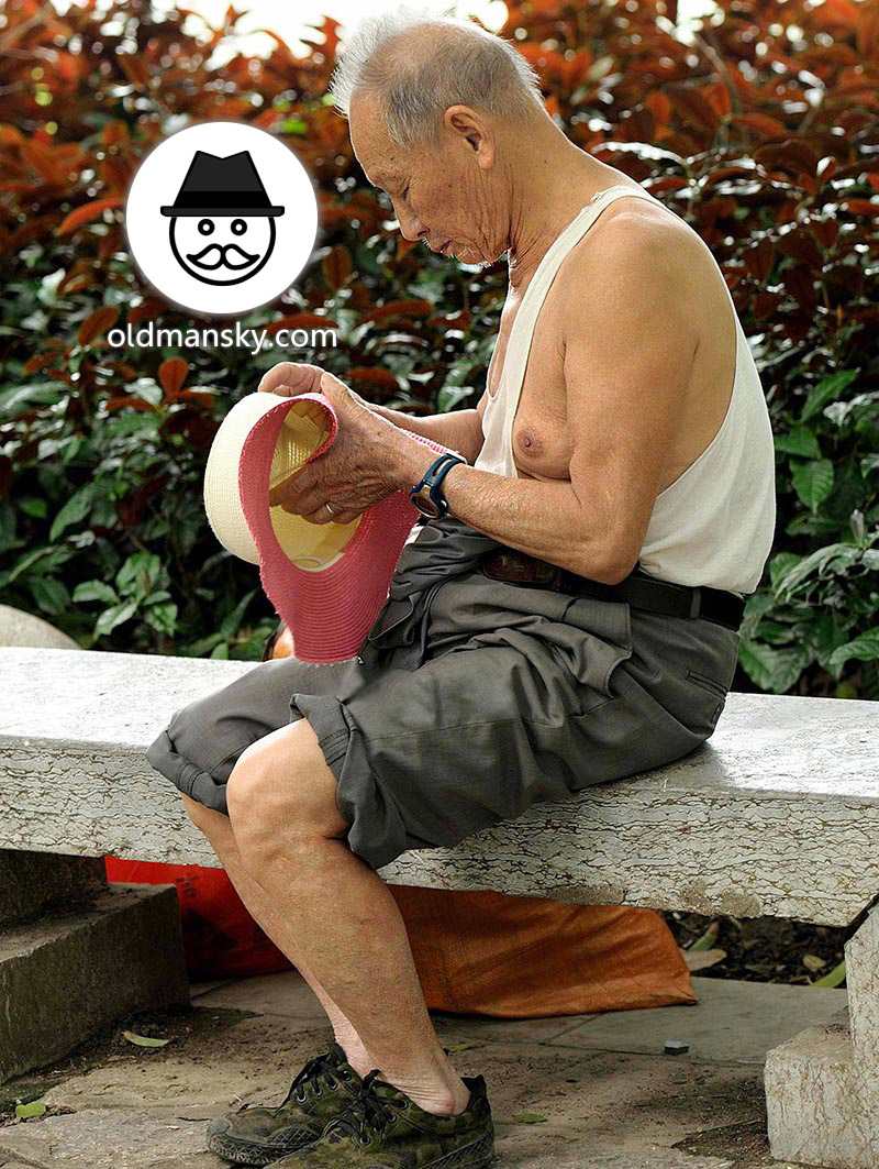 Old man wore white vest undershirt and gray trousers in the park