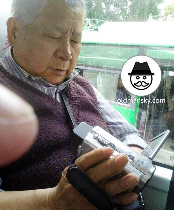 White hair old daddy was playing video recorder by bus