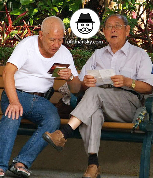 Glasses old man wore white short sleeve shirt sat on the bench in the park_04