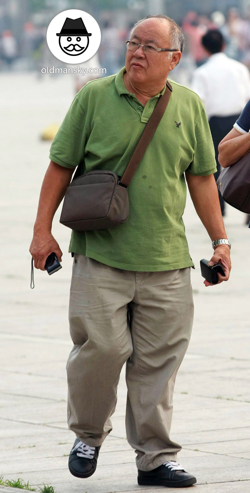 Glasses old daddy wore green polo shirt and white trousers on the square