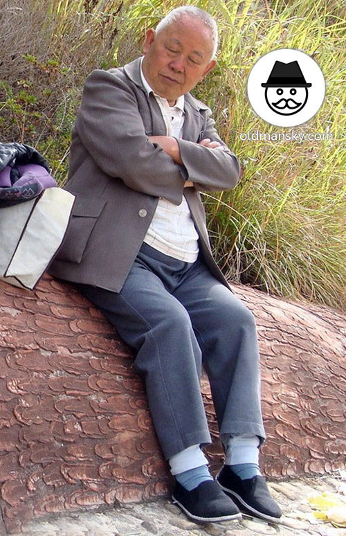 Tourist white hair old man wore gray clothes rest on the stone bench_02