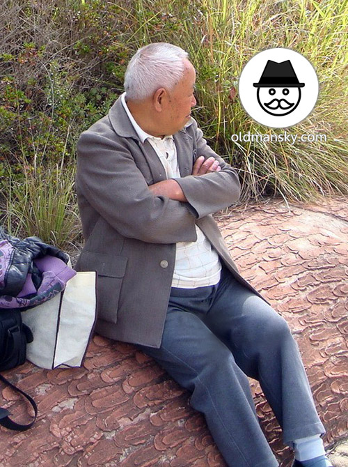 Tourist white hair old man wore gray clothes rest on the stone bench_03
