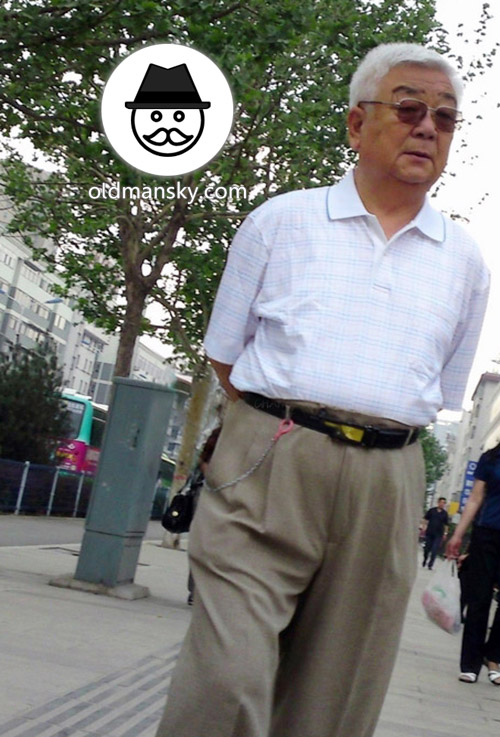 White hair glasses old man wore white polo shirt was walking in the street