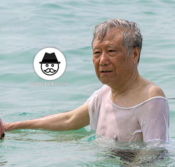 Old man went swimming with clothes at the sea