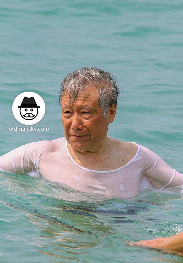 Old man went swimming with clothes at the sea