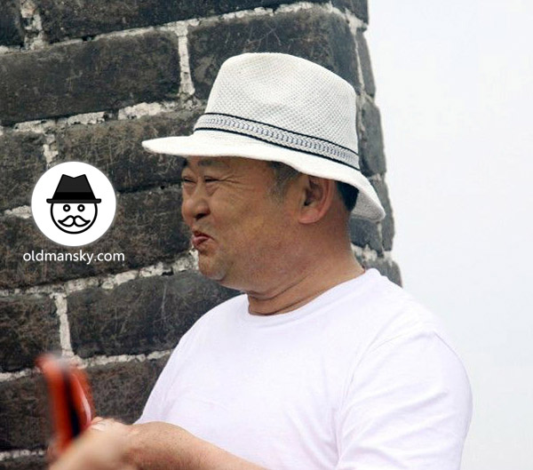Fat old daddy wore a white hat and white T-shirt was eating on the Great Wall