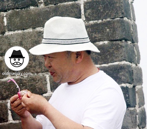 Fat old daddy wore a white hat and white T-shirt was eating on the Great Wall_04