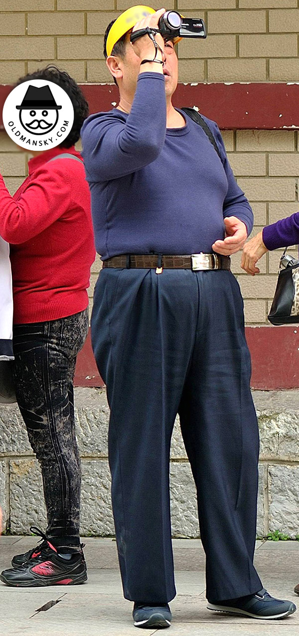 Tourist old daddy wore brown clothes was recording with video camera