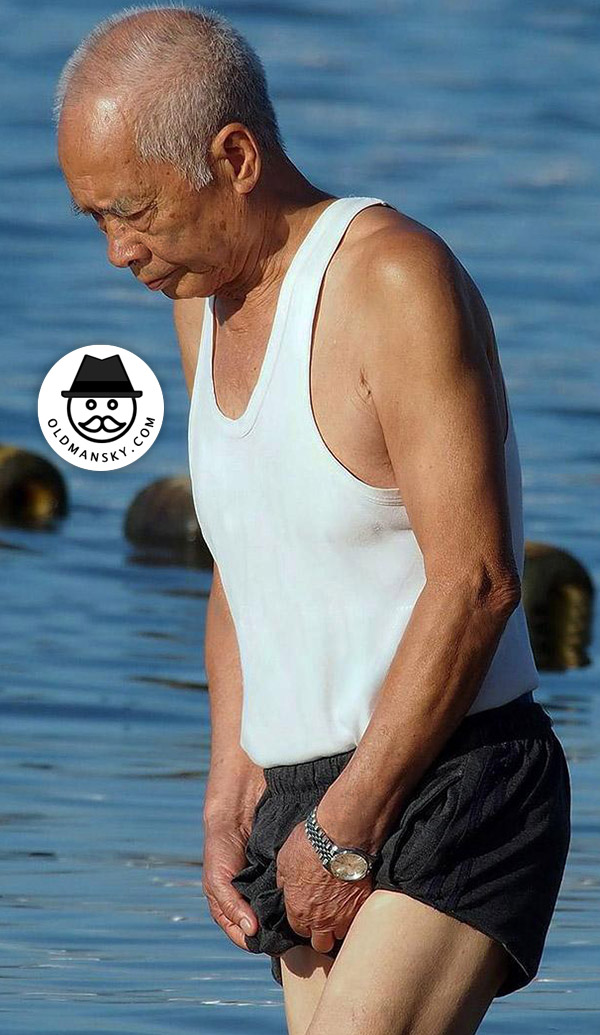 Old man wore a white vest undershirt and a black middle pants at the sea_03